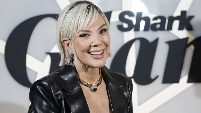 A blonde Kris Jenner smiling while posing at an event