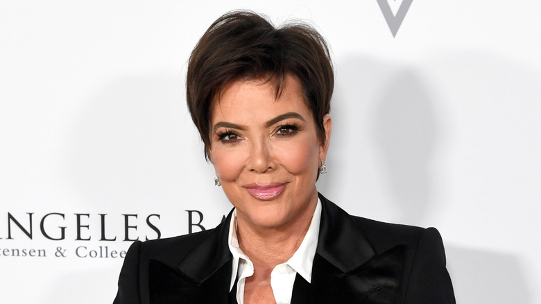 Kris Jenner in a black suit and white shirt in 2020 at an event