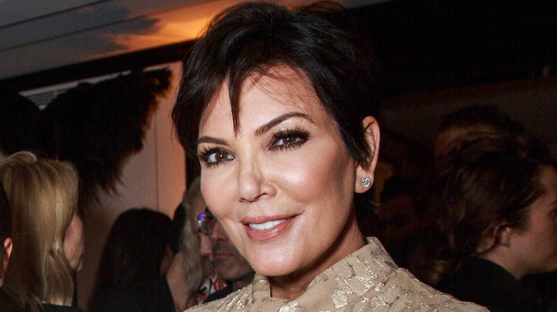 Close-up of Kris Jenner smiling at a party surrounded by guests