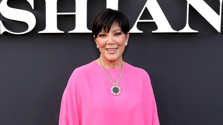 Kris Jenner smiling in a pink dress at a premiere of "The Kardashians"