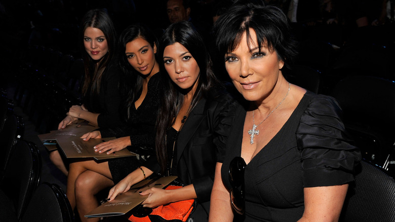 Kris Jenner with Khloé, Kim, and Kourtney Kardashian seated in audience and all dressed in black
