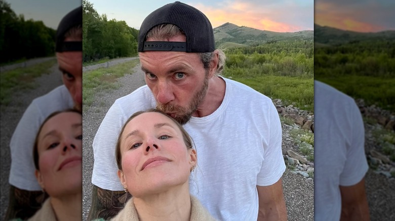 Kristen Bell leans her head back and Dax Shepard kisses her forehead outdoors during sunset.