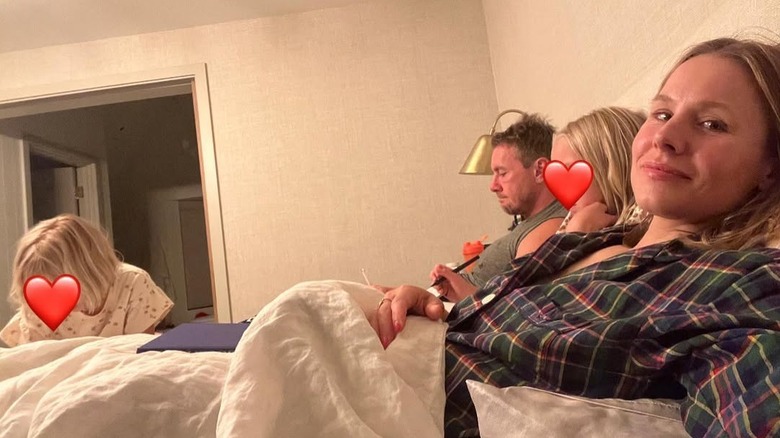Kristen Bell takes a selfie while in bed with Dax Shepard and their two daughters.