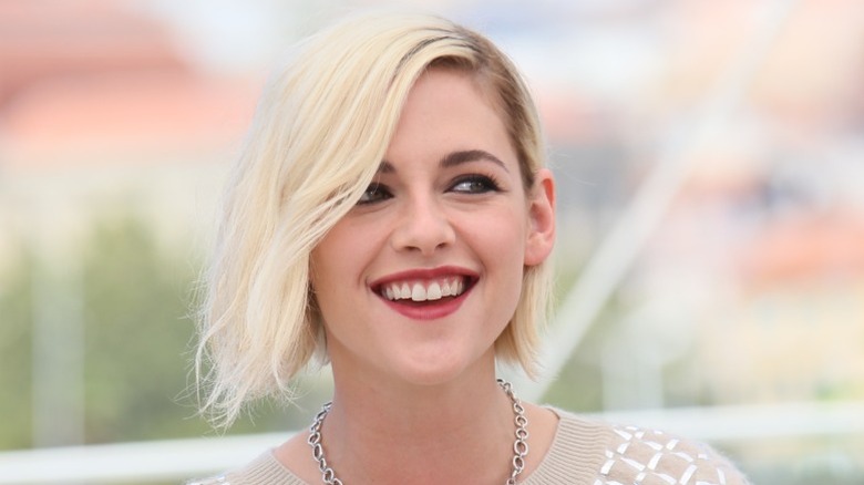 Kristen Stewart smiling with a blonde bob at the Cannes Film Festival