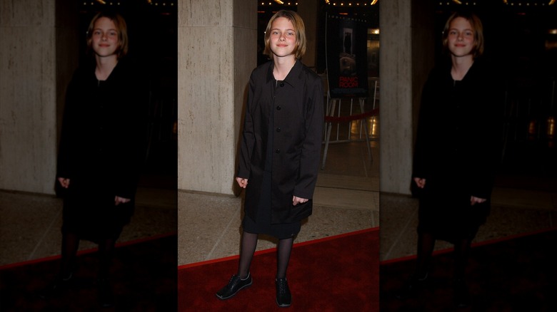 Teenage Kristen Stewart wearing all black and smiling at the premiere of Panic Room.