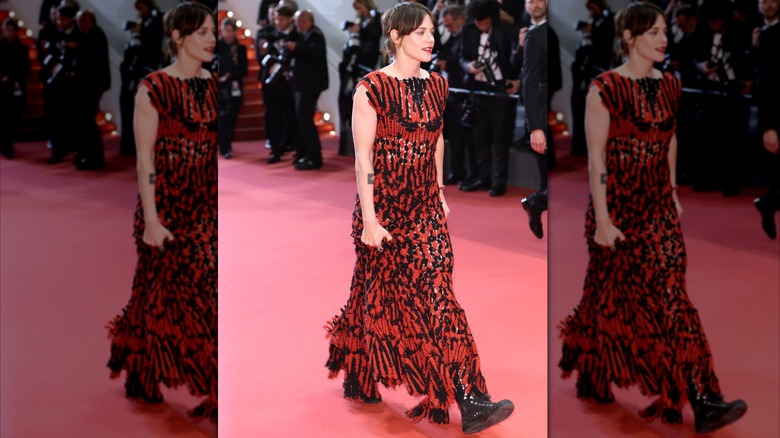 Kristen Stewart wearing a Chanel gown with sneakers on a red carpet.