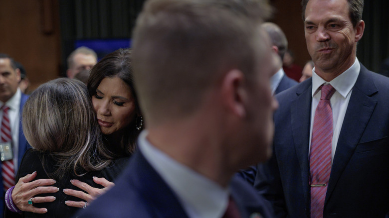Bryon Noem looking on as Kristi Noem hugs someone