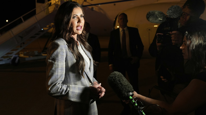 Kristi Noem speaking to reporters before boarding a plane
