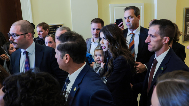 Kristi Noem holding baby in a crowd