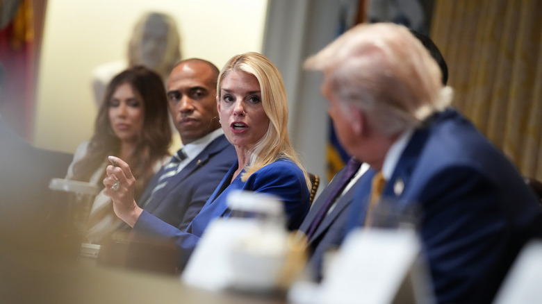 Kristi Noem looks down while Donald Trump listens to comments made by former Attorney General Pam Bondi