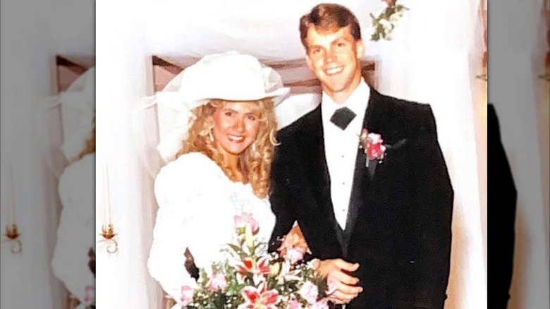 Kristi Noem wearing a white cowboy hat and posing with Bryon Noem on their wedding day
