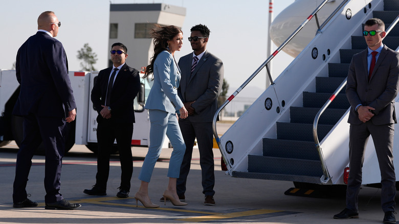 Kristi Noem walking toward airplane steps