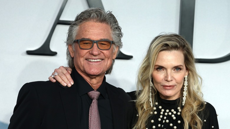 Kurt Russell and Michelle Pfeiffer posing wearing black formal clothes at a premiere.