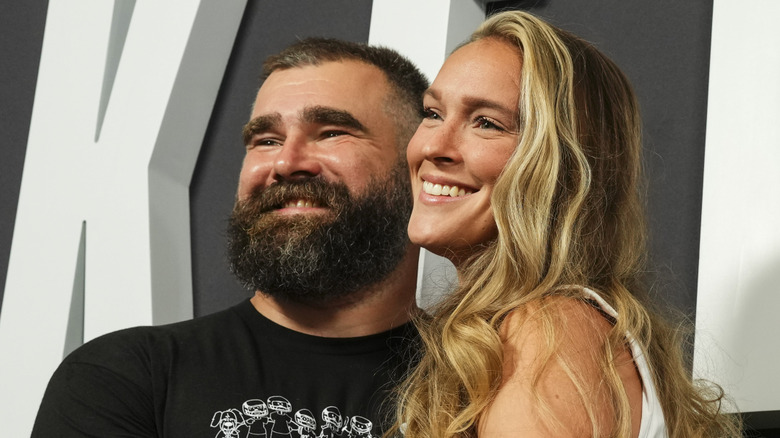 Kylie Kelce and Jason Kelce holding each other in front of Kelce sign.