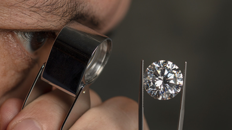 Man looking at a diamond with a magnifying glass