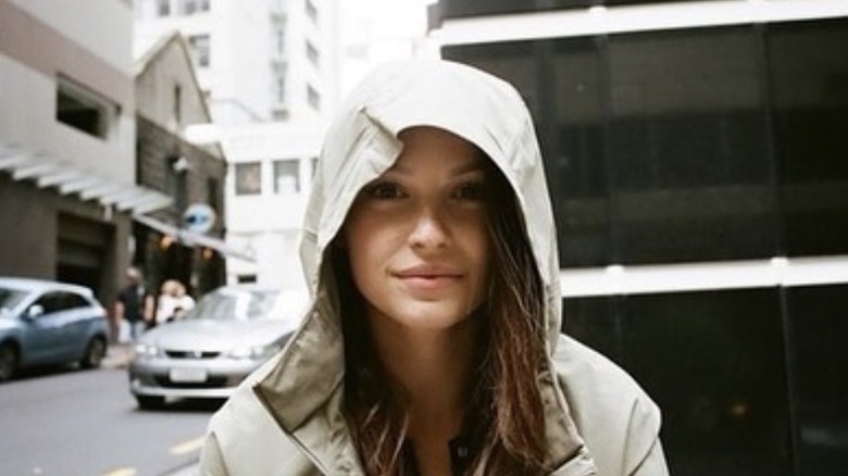 Kayla Wallace wearing a hooded jacket while standing on a city street