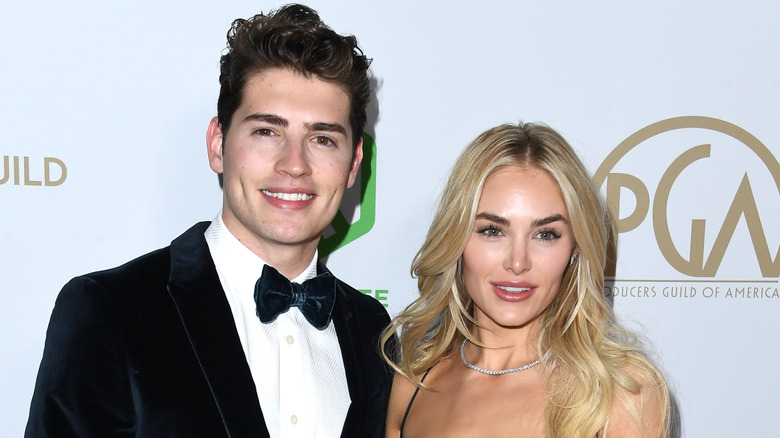 Greg Sulkin and Michelle Randolph standing on the red carpet.