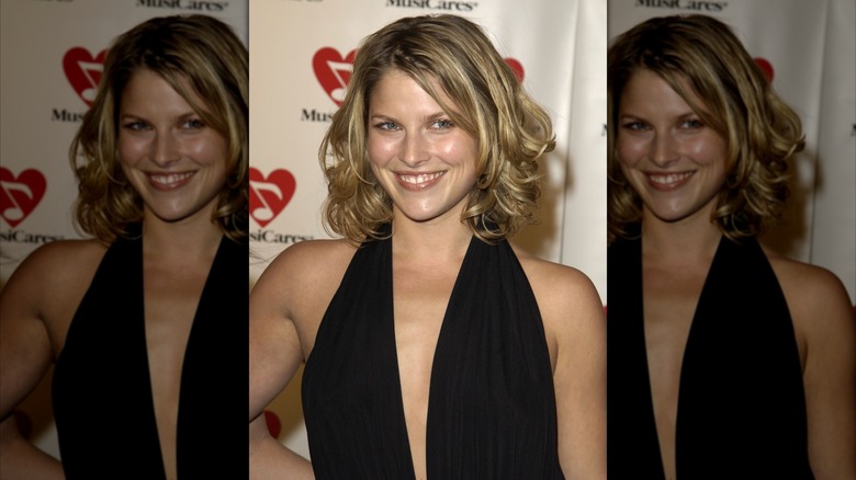 Ali Larter with midlength bob and curls wearing a black dress with a plunging neckline in 2003
