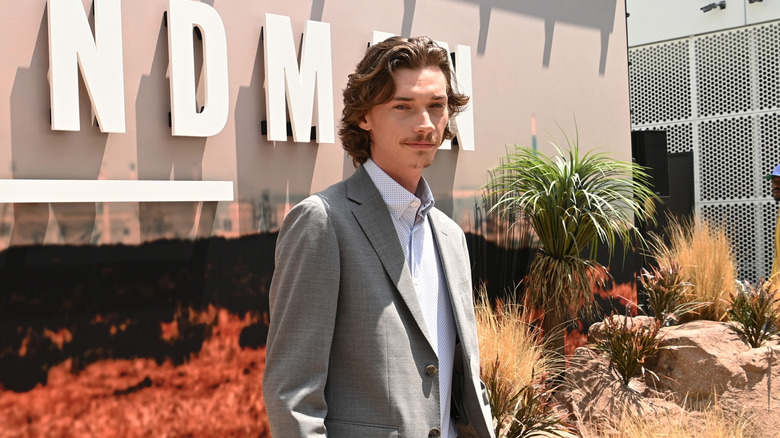 Jacob Lofland poses by a "Landman" billboard