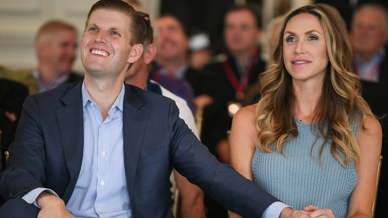 Eric Trump sits next to Lara Trump with his hand on her knee