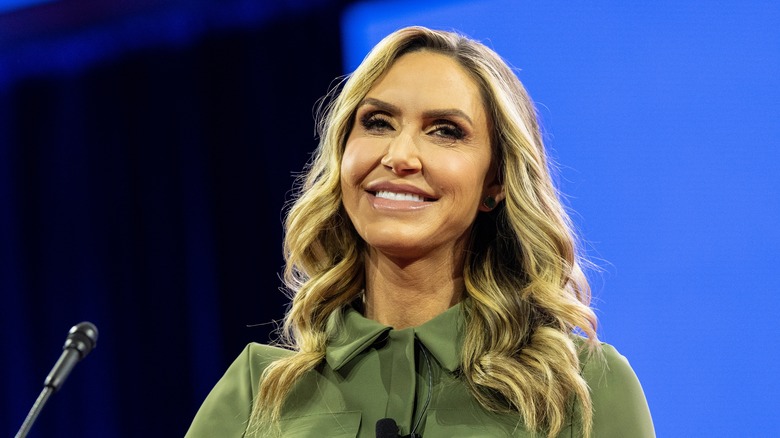 Lara Trump smiles by a microphone