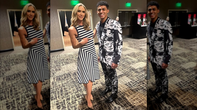 Lara Trump wearing black and white striped dress and posing with man in suit with print of Donald Trump's face