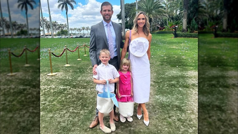 Lara Trump wearing a white dress with large floral detail and posing with family