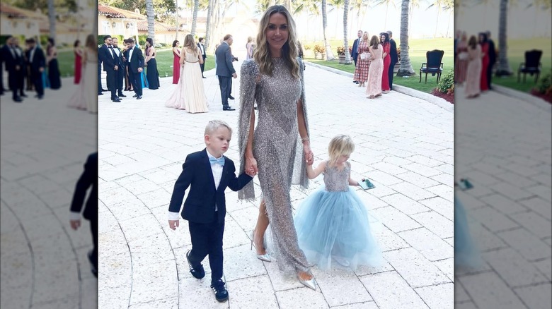 Lara Trump wearing a silver dress and holding hands with her kids at Tiffany Trump's wedding