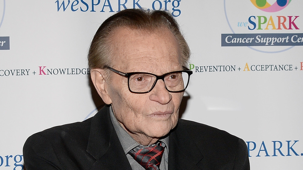Larry King crossing his arms