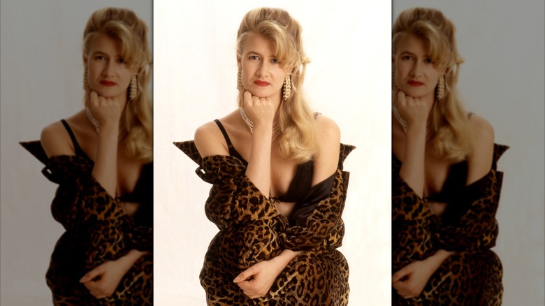 Laura Dern posing for a photoshoot in a leopard print overcoat and black bralette