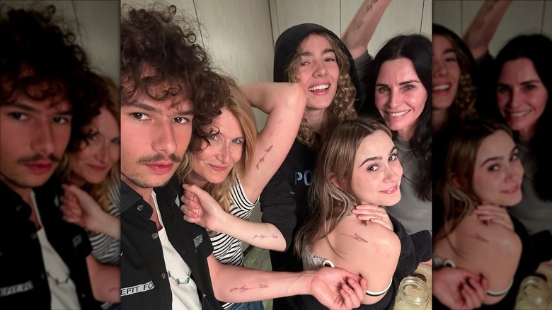 Ellery Harper, Laura Dern, Jaya Harper, Coco Arquette, and Courteney Cox showing off their matching paper paper airplane tattoos.