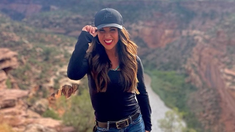 Lauren Boebert smiling with her hand on her hat brim