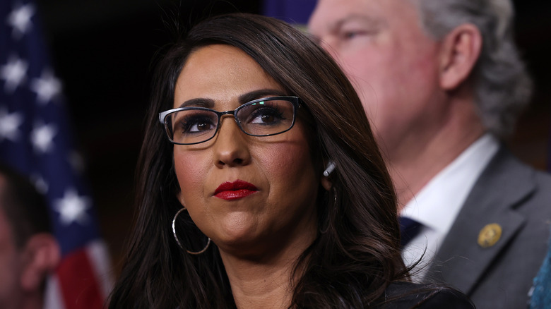 Lauren Boebert staring sideways and wearing a black blazer while attending a press conference.