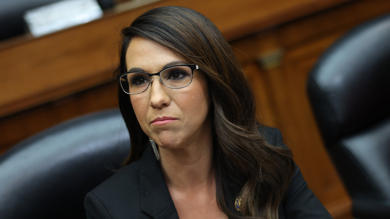 Lauren Boebert sitting at a table wearing a black blazer and long earrings.