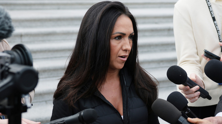 Lauren Boebert surrounded by people holding microphones