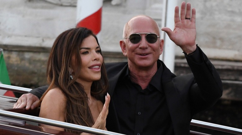 Lauren Sánchez Bezos and Jeff Bezos wave as they exit the Hotel Amman in Venice, Italy (2025)