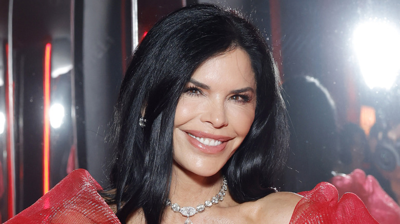 Lauren Sanchez Bezos smiling in a red dress while attending the Vanity Fair Oscar Party.