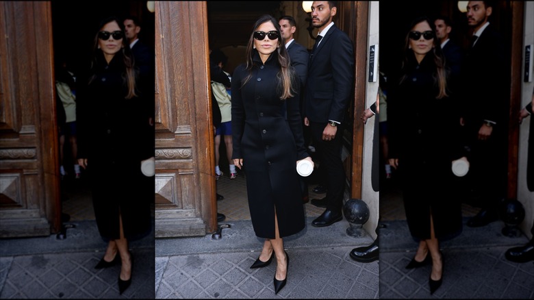 Lauren Sanchez posing in a long black trench coat during paris fashion week.