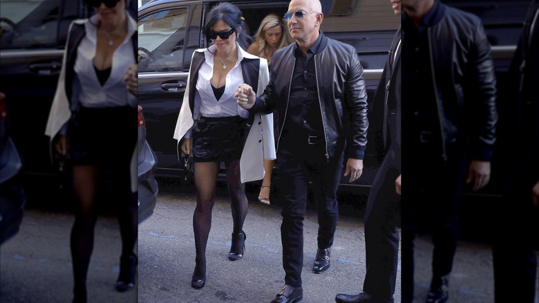 Lauren Sanchez wearing a white collared shirt and mini black dress while holding hands with Jeff Bezos.