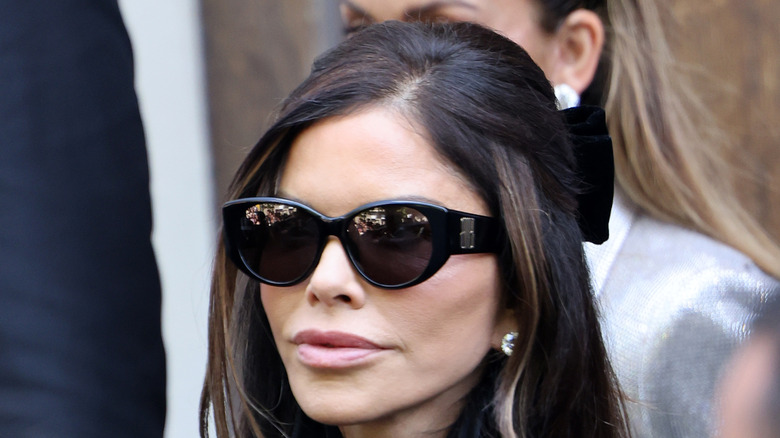 Lauren Sanchez wearing sunglasses and a trench coat.