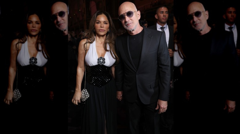 Lauren Sánchez Bezos wearing a black and white halter dress and Jeff Bezos in black