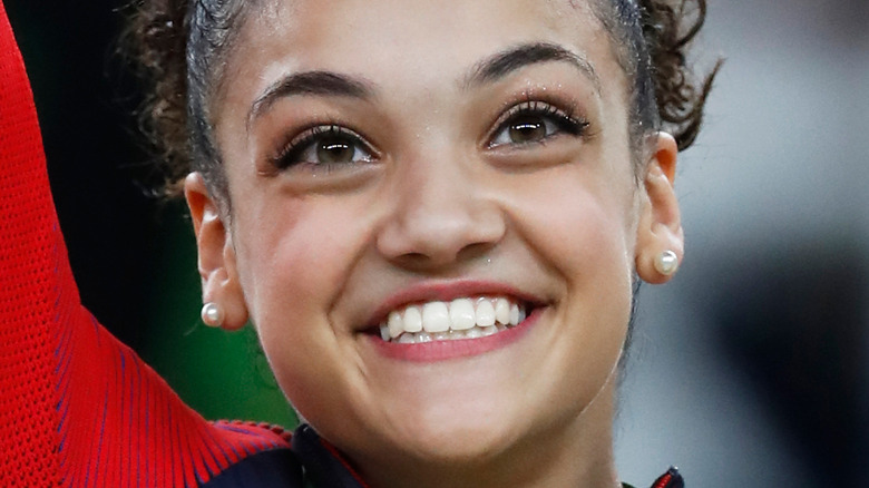 Laurie Hernandez waves while wearing Olympic medal