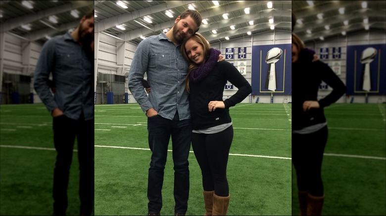 Steve and Mina Hawk on a football field after proposal