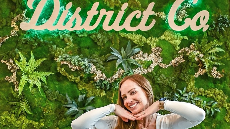 Mina Starsiak Hawk smiling under her store sign