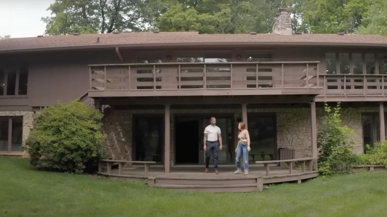 Mina and Steve Hawk standing in the backyard of their lakehouse