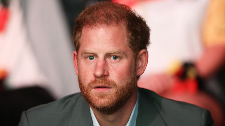 Prince Harry looks straight ahead, wide-eyed