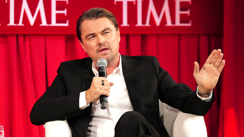 Leonardo DiCaprio sitting and speaking into a mic