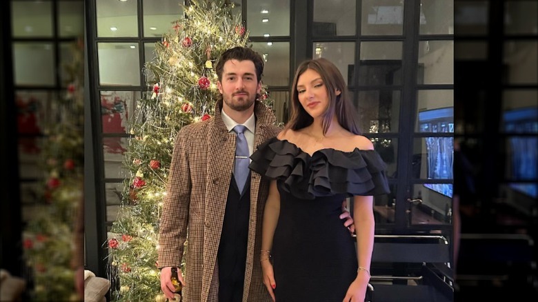 Natalie Ackerman and Daniel Neeson posing in front of a Christmas tree