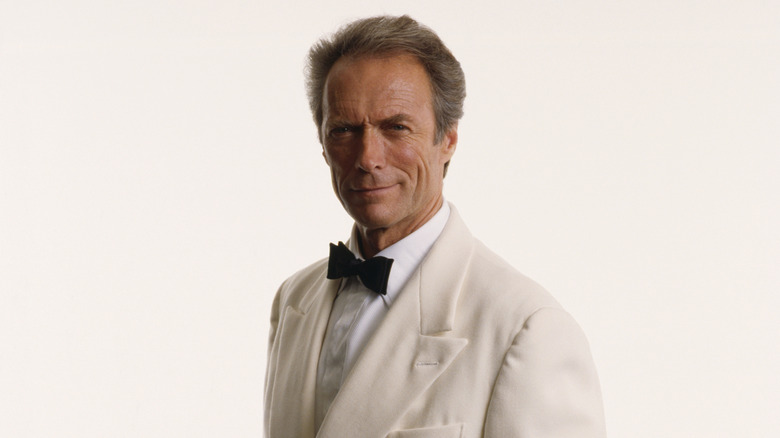 Clint Eastwood smirking at the camera in a white suit