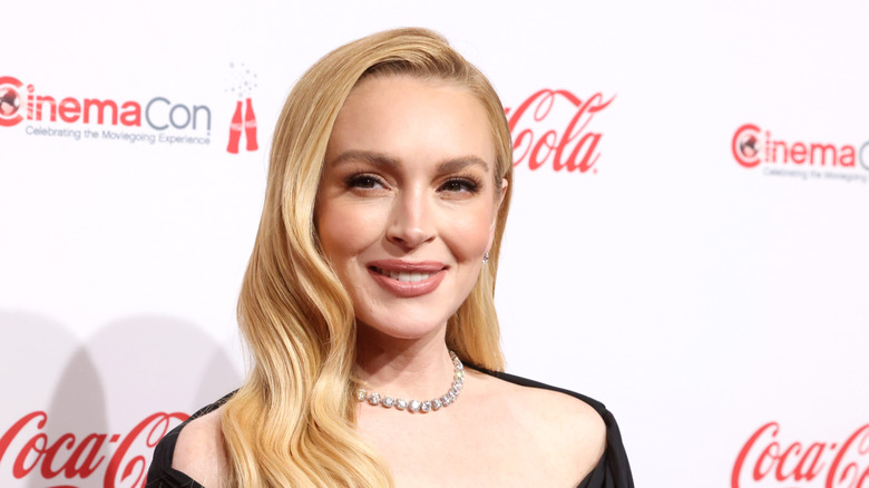 Lindsay Lohan smiling in a black dress at the Cinemacon Big Screen Achievement Awards.